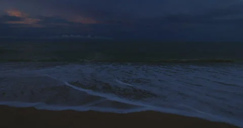 Slow motion, the ocean waves roll break on sand beach in night. Stock Footage 254449458