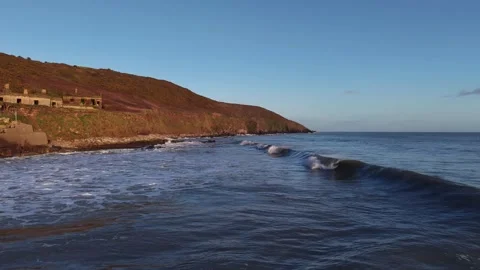 Slow Motion Ocean Waves Rolling Along Rocky Coastline at Sunset Stockbeeldmateriaal 333035853