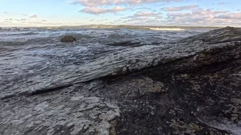 Slow motion ocean waves splashing over rocky coastal slope Stock Footage 325720514
