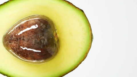 Slow motion of oil drop dripping from fresh avocado fruit over white background Stockbeeldmateriaal 152749876