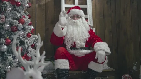 Slow motion of old and long bearded Santa Claus, waving to the camera greetin Stock Footage 252383056