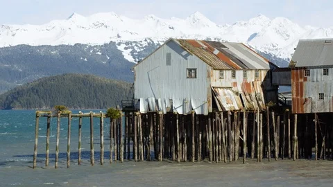 Slow motion of old building falling apart on top of wooden pier on sunny day Stock Footage 129111639