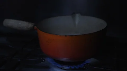 Slow motion Old cast iron pan of boiling water on gas flame stove top kitchen Stock Footage 86543268