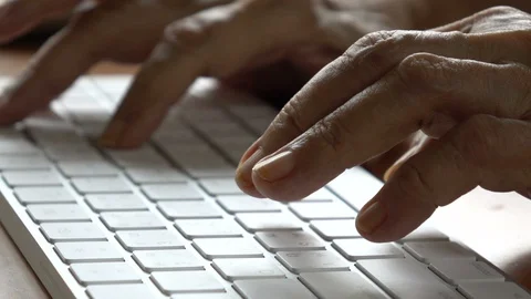 Slow Motion: Old hands of senior person typing on the computer keyboard Stock Footage 130104217