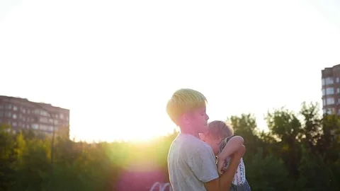 Slow motion. The older child throws his laughing brother into the air. Outdoor Vidéo 78370256