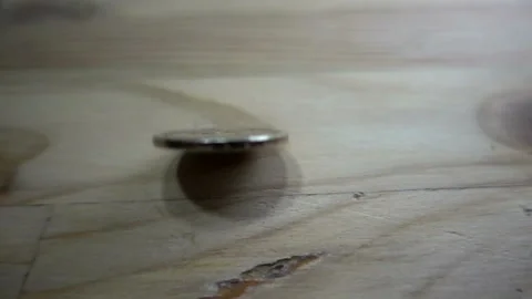 Slow motion of one dollar coin rotates on a wooden table. Stock Footage 102020698