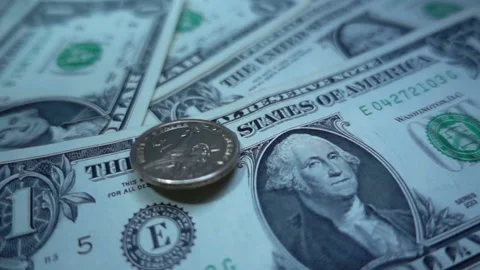 Slow motion of one dollar coin rotates on a one dollar bills Stock Footage 102022258