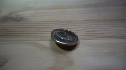 Slow motion of one dollar coin rotates on wooden Stock Footage 102022554