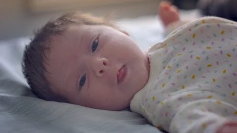 Slow motion of a one-month old baby looking at camera and moving Stock Footage 107572806