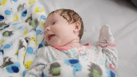 Slow motion of one month old baby moving while lying in bed Stock Footage 107616215