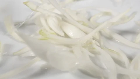 Slow motion onion slices on white background, wet white vegetable falling Stock Footage 88341134