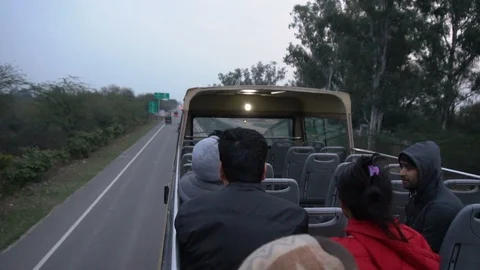 Slow Motion Open Air Tour Bus Driving on Highway in Countryside of India Stock Footage 129346790