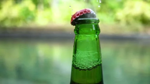 Slow motion: opening of green bottle of beer by opener. Stock Footage 104060504