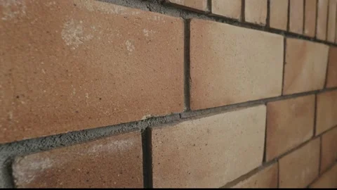 Slow motion of an orange brick wall filled with gray concrete. Stock Footage 267696009