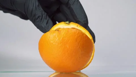 Slow motion orange cut in slow motion. Man in black gloves slice orange fruit Stock Footage 150768111