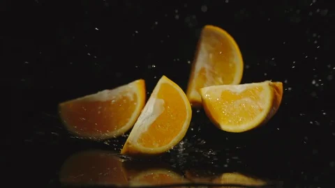 SLOW MOTION: Orange falls on a table and pieces scatters in different directions Видео 97914340
