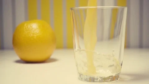 Slow motion orange juice with pulp is poured into a glass Stock Footage 72048678