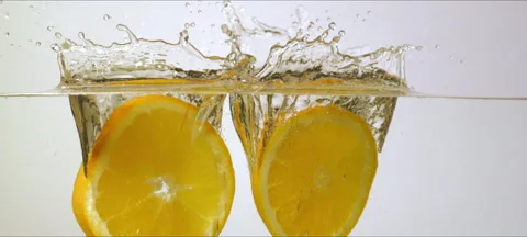 Slow motion oranges splash into water. Refreshing and vibrant macro Stock Footage 323438327