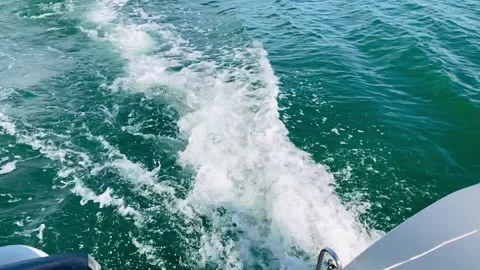Slow-motion out the back of a catamaran of the engine wake and waves. 库存影片 154381841
