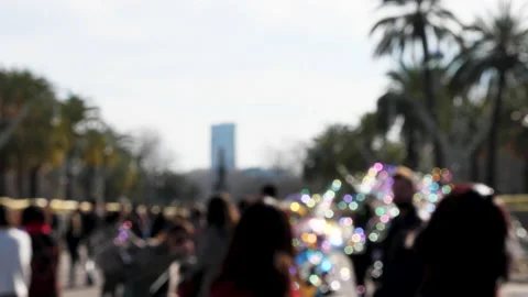 Slow motion out of focus shot of soap bubbles and blurred people on a crowded Видео 132647931