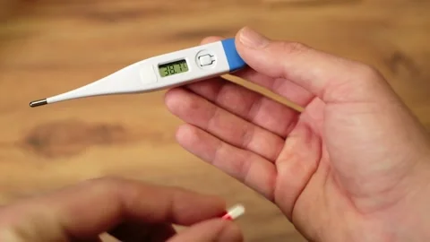 Slow Motion Overhead Hand Dropping Capsule to Thermometer Stock Footage 327389956