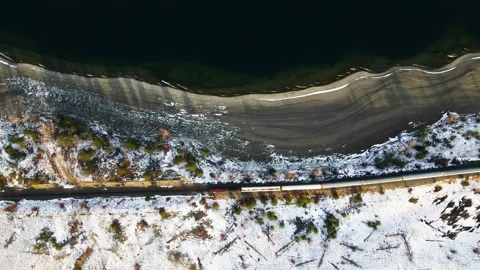 Slow Motion Overhead Shot of a red train passing by the beaches of Stock Footage 228179488