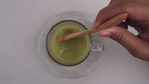 Slow motion overhead shot of stirring matcha or green tea Stock Footage 278017907
