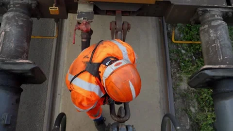 Slow motion Overhead Static Shot: Rail Worker in Hi-Vis Inspecting Train Stock Footage 338371718