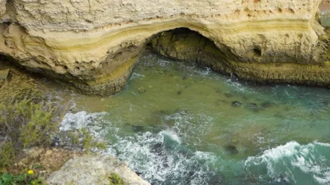 Slow motion overhead view of waves breaking over rocky cliffs Stock Footage 168974067