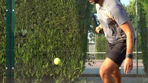 Slow motion of a paddle tennis player kicking the ball on an outdoor court. Stock Footage 159201180
