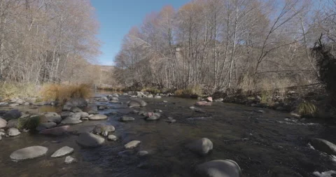 Slow Motion Pan Along River Rocks and Stream Water Flows Stock Footage 146663463