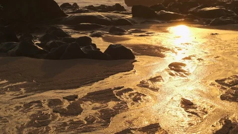 Slow motion pan up on beach at sunset. Water flowing through sand Stock Footage 116755596