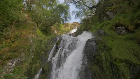 SLOW MOTION PAN UP OVERGROWN GREEN WATERFALL SUMMER IN THE LAKE DISTRICT, UK 4K Stock Footage