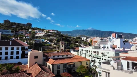 Slow motion pan of Puerto de la Cruz cityscape with Mount Teide, Tenerife Stock Footage 346471899