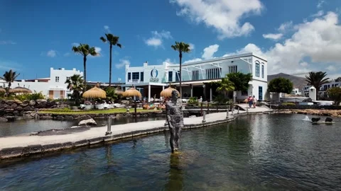 Slow motion pan of resort pond and sculpture, Playa Blanca, Lanzarote Stock Footage 346376271