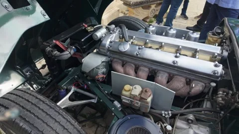 Slow-motion pan of a restored jaguar e-type engine bay at a car exhibition in Video stock 323896830