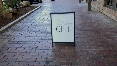 Slow motion pan up to reveal "Come In We're Open" business sign Stock-Footage 201828065