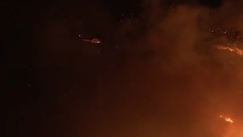 Slow motion, pan shot of a fire fighter copter, extinguishing at the Stock Footage 121465755