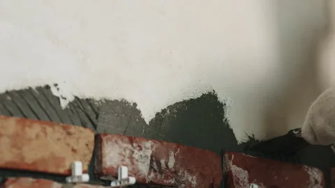 Slow motion pan worker remove excessive concrete glue to wall before applying Stock Footage 280307963