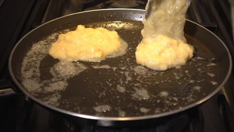 Slow motion: pancake batter / mix dropping from a spoon into a frying pan. Stock Footage 89645075