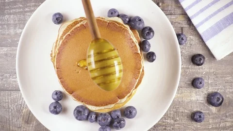 Slow motion pancakes for breakfast with berries and honey top view Stock Footage 92949998