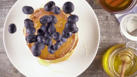 Slow motion pancakes for breakfast with berries and honey top view Video stock 92950225