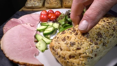 Slow motion - Panini bread roll being added to a plate of ham salad. Video stock 119600567