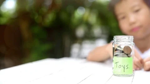 Slow motion panning camera of Boy saving coin  스톡 동영상 80295701