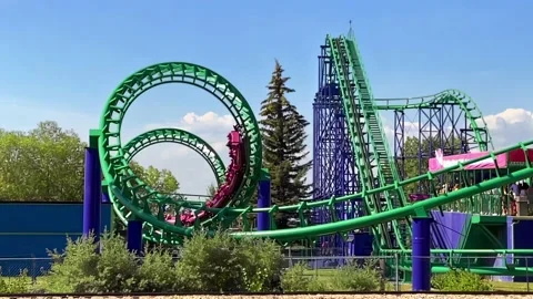 A slow motion panning of a roller coaster ride with twisty turns and an upside Stock Footage 204833417