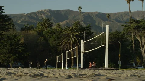 Slow motion panning shot of group of adults playing beach volleyball Stock Footage 174849019
