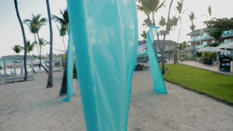 Slow motion parallax shot of beach with blowing fabric in the foreground Stock Footage 235367602
