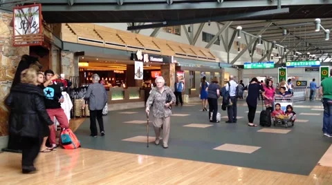 Slow motion of passengers with luggage inside yvr airport Stock Footage 41898338