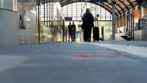 Slow-motion of passengers walking by on train station platform Видео 115484081