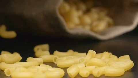SLOW MOTION: Pasta fall near a lying cloth bag Video stock 72495859